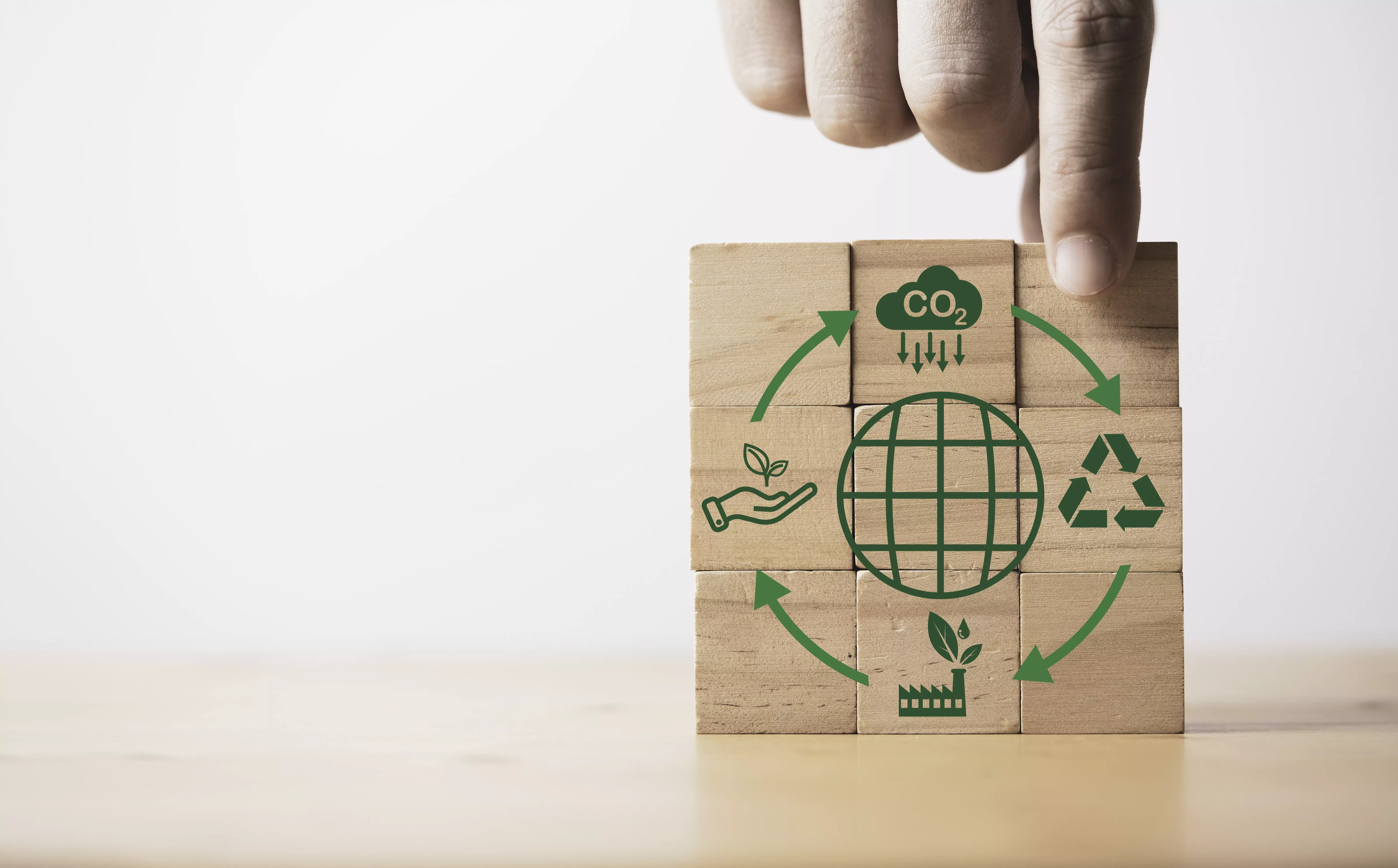 Holzwürfel mit Umwelt-Icons und Hand